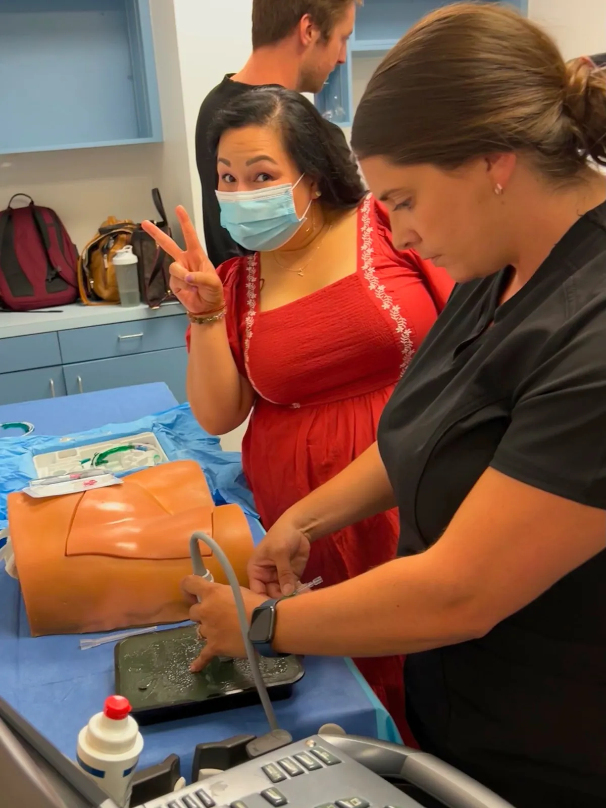 Faculty teaching an ultrasound-guided procedure on a simulation task trainer